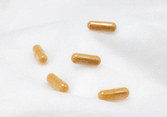 Natural supplement capsules on a clean white surface