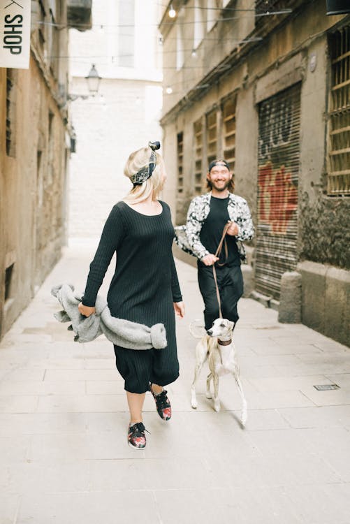 Happy couple running outdoors with their dog