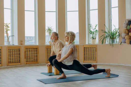 Senior couple doing stretching exercises on yoga mats