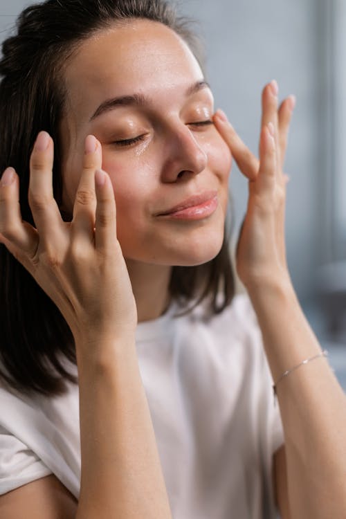 Woman applying skincare products for healthy glowing skin